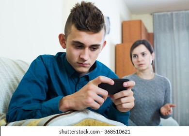 Teen Age Son Playing With Phone, Mother Trying To Talk 
