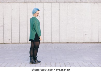 Teen Androgynous Woman On A Sad Expression With Blue Dyed Hair Isolated On The Street Wearing A Blue Sweater.