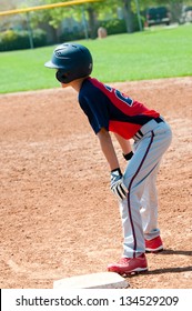 Teen Baseball Player Waiting On First Base.