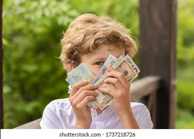 Teen blond boy in white shirt holding money at his hands - Powered by Shutterstock