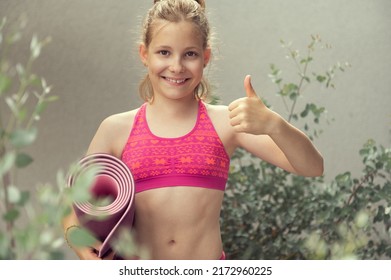 Teen Blonde Girl Holding Yoga Mat And Showing Thumb Up Sign Before Workout