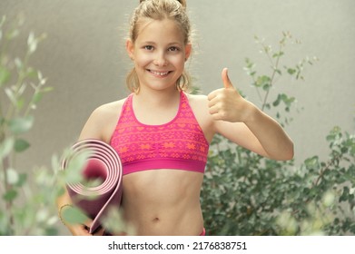 Teen Blonde Girl Holding Yoga Mat And Showing Thumb Up Sign Before Workout