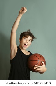 Teen Boy With Basketball Ball And Sleeveless T-shirt Hand Up In Victory Gesture