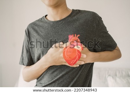 Teen boy clutching chest with heart anatomy, heart attack, heart disease, health concept