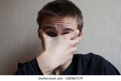 Teen Boy Covers His Face With His Hands