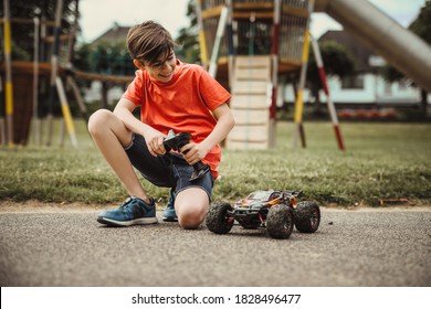 Teen Boy With Electric Remote Control Car Toy Play Outdoor On Sidewalk And Have Fun While Enjoy His Childhood