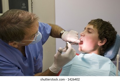 Teen Boy Getting An Injection From The Dentist.