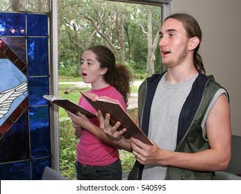 A Teen Boy And Girl Singing Hymns In Church.