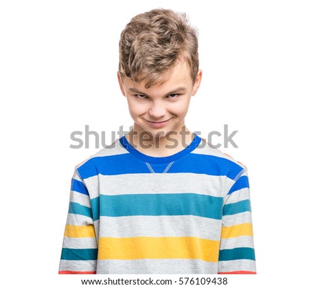 Teen boy making silly grimace - expressing cunning face. Upset child isolated on white background. Emotional portrait of caucasian teenager looking at camera.