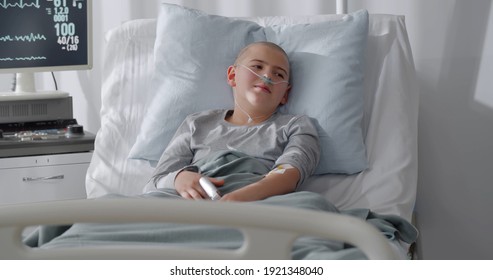 Teen Boy Patient Lying In Hospital Ward. Sick Bald Kid With Nasal Tube Lying In Hospital Bed After Chemotherapy