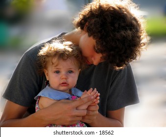 Teen Boy Playing With A Baby Girl