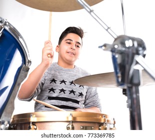 Teen Boy Plays The Drums In Studio Against White Background