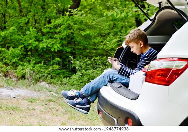 teen boy sitting in the\
car with phone