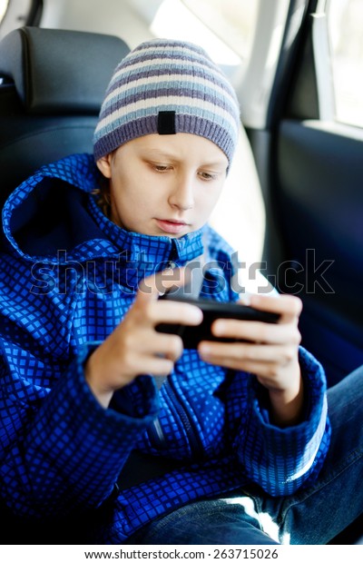 teen boy sitting in the
car with phone