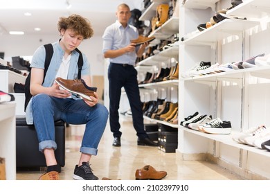 Teen Boy Trying On Classic Brown Shoes At Shoe Store