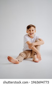 Teen Boy In White T-shirt Pose For A Photographer In A Photo Studio. Transitional Age Problems For Teenage Boys. Shooting For A Graduation Photo Album At School. Happy Childhood