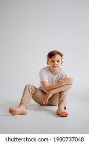 Teen Boy In White T-shirt Pose For A Photographer In A Photo Studio. Transitional Age Problems For Teenage Boys. Shooting For A Graduation Photo Album At School. 