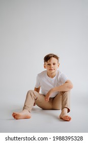 Teen Boy In White T-shirt Pose For A Photographer In A Photo Studio. Transitional Age Problems For Teenage Boys. Shooting For A Graduation Photo Album At School. 