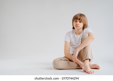 Teen Boy In White T-shirts Pose For A Photographer In A Photo Studio. Transitional Age Problems For Teenage Boys. Shooting For A Graduation Photo Album At School. 
