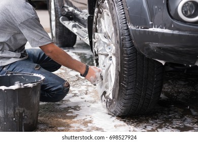 Teen Boys Are Washing Black Car By Using A Sponge With A Shampoo, Rub The Wheel Cleaner. To Clear The Dirt Off.