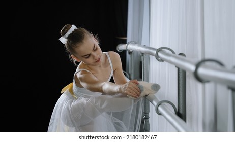 Teen Caucasian Ballerina Girl Teenager Dancer Child Student In Dance Hall Doing Choreographic Exercise At Dance School Class Near Ballet Barre Stretching Feeling Foot Pain Knee Injury Stretch Problem