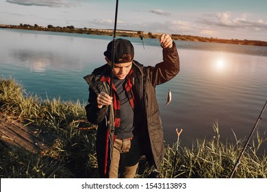 Teen Caucasian Boy Caught First Fish. He Hold Fishing Rod And Fish.