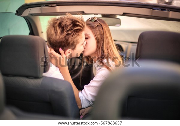 Teen couple kissing in the car\
