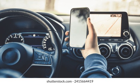 Teen drive a car and use smartphone. Young man reading messages holding a cell phone while driving. Dangerous behavior, accident risk. Danger, transgression, youth, distraction concept. Focus on hand. - Powered by Shutterstock