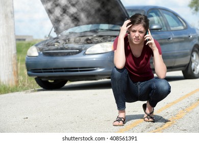 Teen driver calling for help after car over heated and is broken down on the side of the road. - Shutterstock ID 408561391