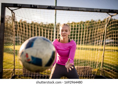 Teen Female Goalie Catching A Shot During A Soccer Game