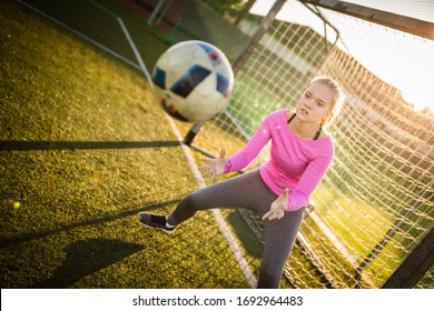 Teen Female Goalie Catching A Shot During A Soccer Game