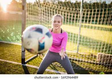 Teen Female Goalie Catching A Shot During A Soccer Game