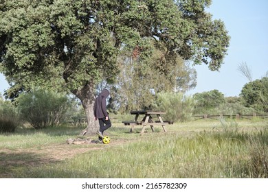 Teen Football Player Near Tree In Countryside