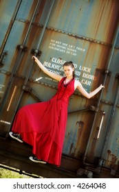 Teen Girl In A Beautiful Gown And Sneakers, Hanging Onto A Rusty Old Boxcar.