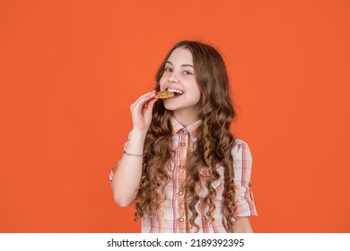 Teen Girl Biting Oatmeal Cookies On Orange Background