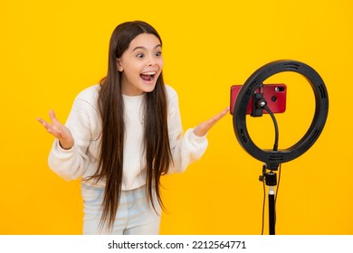 Teen girl blogger use selfie led lamp and smartphone on tripod for making online video tutorial. Teenager vlogger making vlog for kids channel. Excited face. Amazed expression, cheerful and glad. - Powered by Shutterstock