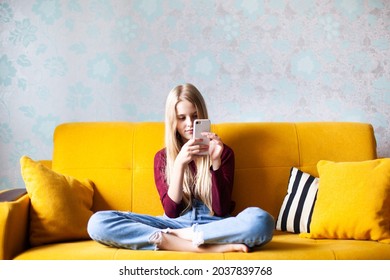 Teen Girl Checking Social Media Using Smartphone At Home. Female Relaxing Playing Mobile Games, Ordering Delivery On A Sofa. Homeschooling, Online Courses, Online Shopping Concept. 