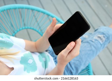 Teen Girl  Is Checking Social Media Holding Smartphone Outside.