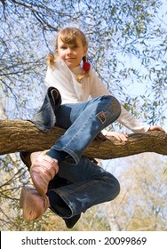 Teen Girl Climbing On The Tree In An Autumn Park