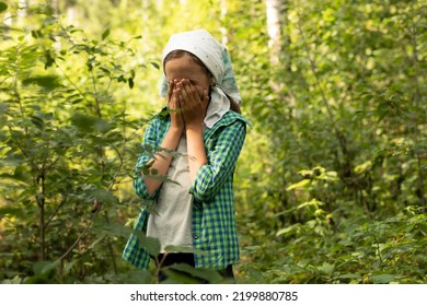 Teen Girl Closes Her Face By Arms Crying In The Green Dense Forest In Summer Time, Wears Plaid Shirt, Black Trousers, White Kerchief. Lost In Woods, Rescuer, Lifesaver Concept. Horizontal Plane