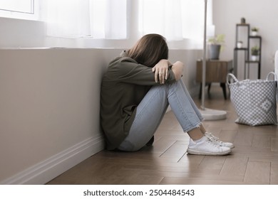 Teen girl crying seated on floor, suffers from bullying, pressure or intimidation from peers at school, feel upset due to social situation, conflict with friends, domestic abuse violence from parents - Powered by Shutterstock