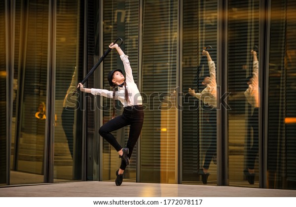 Teen girl dancing modern jazz among golden\
reflections in the mirror\
walls