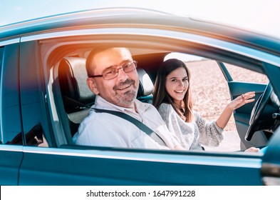 Teen Girl Driving Father By Car For The First Time. Teenage Woman And Man Going On Small Trip Together