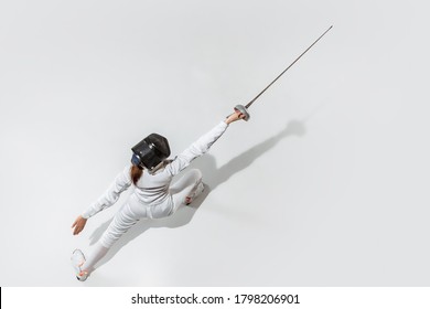 Teen girl fencing with sword on white background, top view. Sport, action