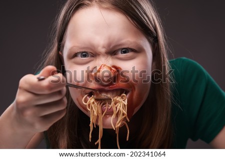 Teen girl furiously eating her food with ketchup on her face