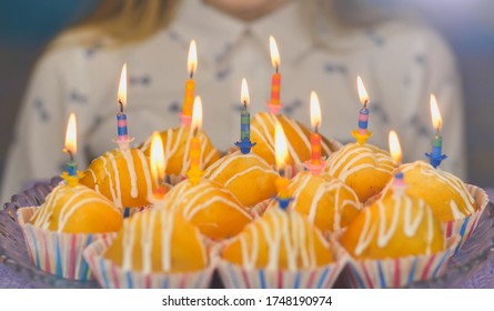 Teen girl getting ready blows out candles on cake cakes on her birthday.