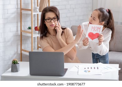 Teen Girl Giving Greeting Card To Her Busy Mother, Irritated Mom Not Paying Attention, Taking Urgent Phone Call. Working Parent Having No Time For Her Kid. Parenting During Coronavirus Outbreak