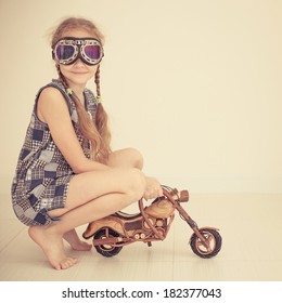 teen girl in glasses on toy motorcycle