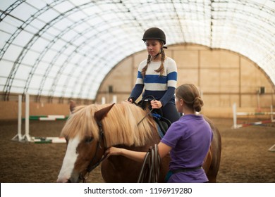 Teen girl in helmet learning Horseback Riding, equestrian - Powered by Shutterstock