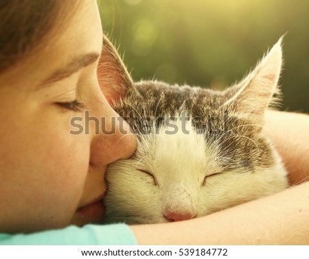 teen girl hug cat close up portrait on the summer garden background